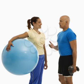 Royalty Free Photo of a Man Standing Next to a Woman Holding an Exercise Ball