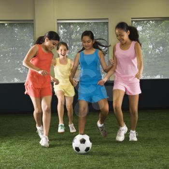 Royalty Free Photo of Girls Playing Soccer and Laughing in an Indoor Gym