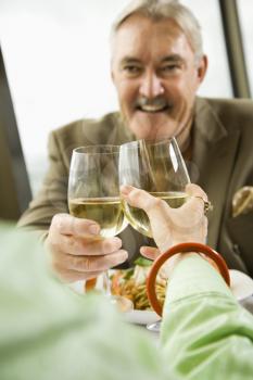 Royalty Free Photo of an Older Couple Dining and Toasting in a Fancy Restaurant