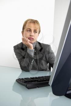 Royalty Free Photo of a Woman Looking Bored at a Computer