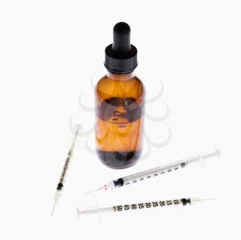 Royalty Free Photo of Hypodermic Needles Beside a Dropper and Bottle