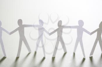 Royalty Free Photo of Cutout Paper Men Holding Hands