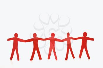 Royalty Free Photo of Red Cutout Paper Men Standing Holding Hands