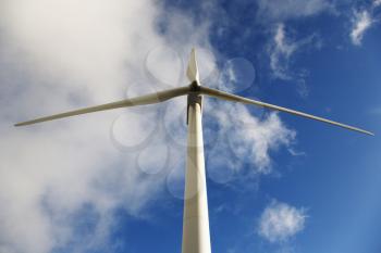 Royalty Free Photo of a Wind Turbine Against a Blue Sky and Clouds