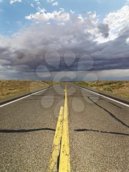 Royalty Free Photo of a Two Lane Highway Leading to a Desert Horizon