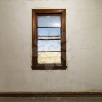Royalty Free Photo of an Empty Abandoned Room With a Window Centered on the Wall