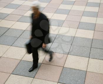 Royalty Free Photo of a Motion Blur of a Businessman Walking Outdoors With a Briefcase
