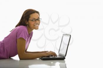 Royalty Free Photo of a Woman Lying on the Floor Using a Laptop and Smiling