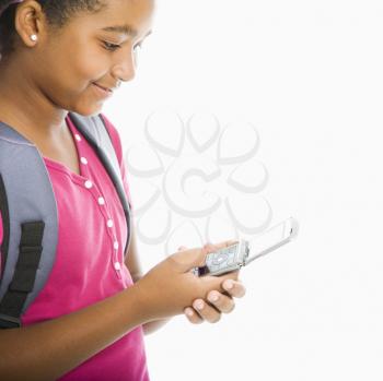 Royalty Free Photo of a Girl With Backpack Sending a Text Message From a Cellphone
