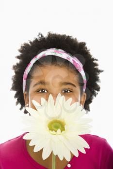 Royalty Free Photo of a Girl Holding a Large Gerber Daisy Over Her Face