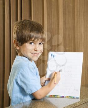 Royalty Free Photo of a Smiling Boy Holding Up His Homework