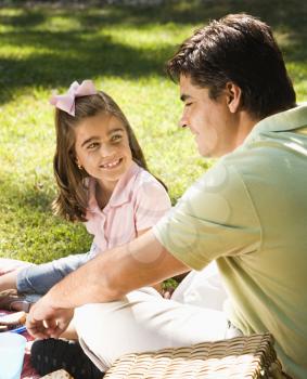 Royalty Free Photo of a Father and Daughter Sitting Outside Smiling