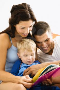 Royalty Free Photo of Parents and Toddler Son Reading a Book
