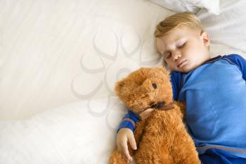 Royalty Free Photo of a Toddler Boy Sleeping With a Teddy Bear