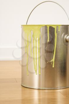 Royalty Free Photo of a Paint Can with Drips Sitting on Wood Floor
