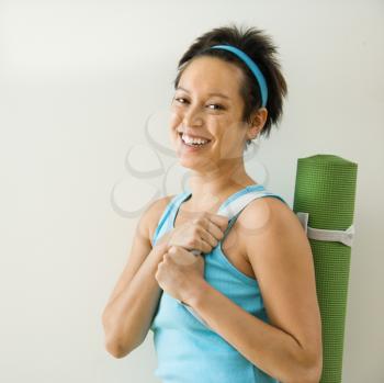 Royalty Free Photo of a Woman Holding a Yoga Mat Smiling