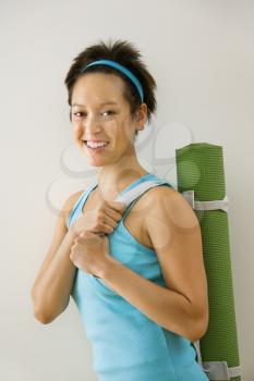 Royalty Free Photo of a Woman Holding a Yoga Mat Smiling