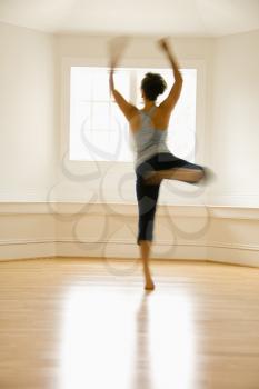 Royalty Free Photo of a Young Woman in Dancing By a Sunlit Window