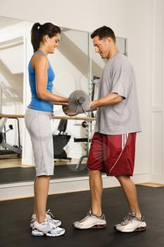 Royalty Free Photo of a Man and a Woman Lifting Weights in a Gym