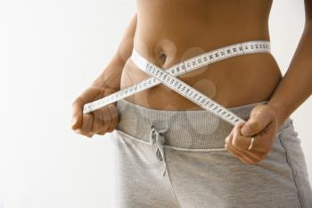 Royalty Free Photo of a Woman Measuring Her Waistline