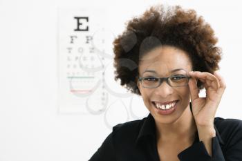 Royalty Free Photo of a Woman Wearing Glasses With a Medical Eye Chart in the Background