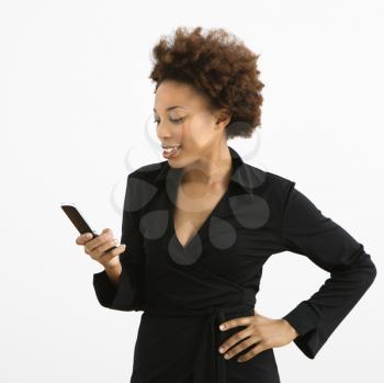 Royalty Free Photo of a Woman Standing Looking at Her Cellphone