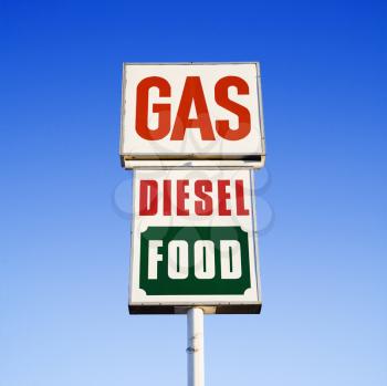 Royalty Free Photo of a Sign Against a Blue Sky That Reads Gas, Diesel and Food