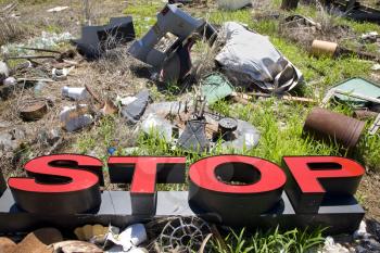 Royalty Free Photo of the Word 'STOP' Lying Amongst Junk and Garbage