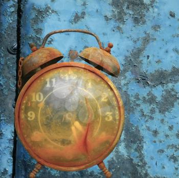 Royalty Free Photo of an Old Alarm Clock Against a Rusty Blue Metal Background