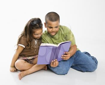 Royalty Free Photo of a Brother and Sister Reading a Book Together