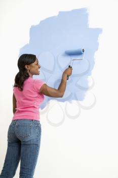 Royalty Free Photo of a Woman Painting a Wall Blue