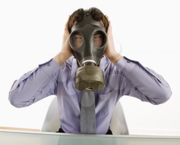 Royalty Free Photo of a Businessman Wearing a Gas Mask Covering His Ears 