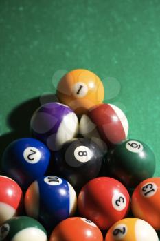 Cropped view of racked pool balls on a pool table. Vertical shot.