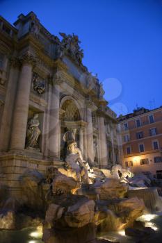 Trevi Fountain at night with lights under the water lighting the statuary. Vertical shot.