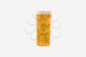 Yellow plastic medicine bottle filled with pills. Horizontal shot. Isolated on white.