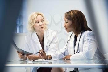 Female doctors discussing patient x ray films.