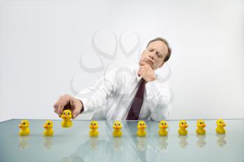 Portrait of middle aged  Caucasian businessman sitting at desk with ducks in a row.