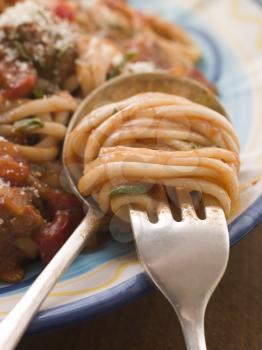Royalty Free Photo of Spaghetti and Tomato Sauce Being Wound on a Spoon and Fork