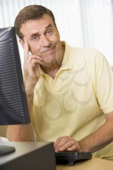 Royalty Free Photo of a Man Looking Puzzled at a Computer
