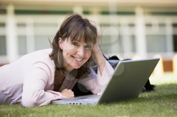 Royalty Free Photo of a Woman Lying on the Grass With a Laptop