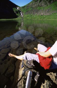 Royalty Free Photo of a Woman on a Rock at a Lake