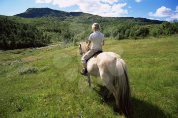 Royalty Free Photo of a Woman Riding a Horse