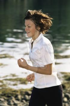 Royalty Free Photo of a Happy Woman Running Beside a Stream