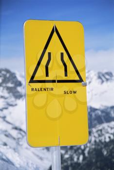 Royalty Free Photo of a Slow Sign on a Snowy Mountain