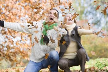 Royalty Free Photo of a Couple Playing in the Leaves