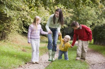 Royalty Free Photo of a Woman and Three Children Walking on a Trail