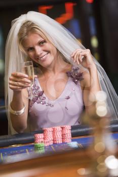 Royalty Free Photo of a Woman in a Bridal Veil at a Roulette Table