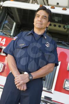 Royalty Free Photo of a Firefighter Standing in Front of an Engine