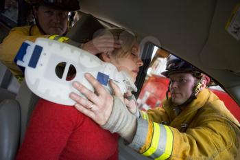 Royalty Free Photo of Firefighters Helping a Car Crash Victim