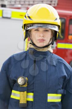 Royalty Free Photo of a Firefighter Beside a Firetruck